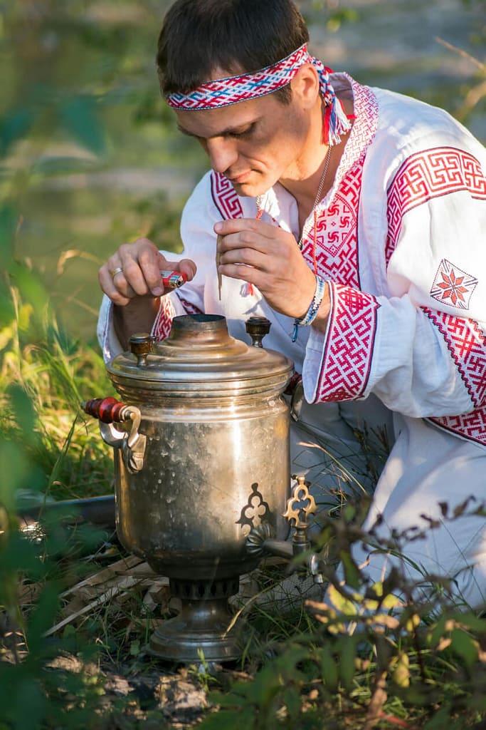 Man lighting samovar, an important tea accessory in Russian tea culture