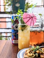 pineapple berry blush iced tea next to tea tin and jug and egg salad toast
