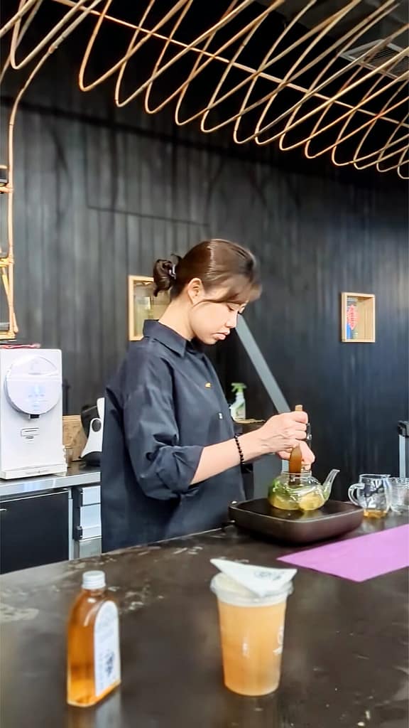woman brewing tea at Tea+