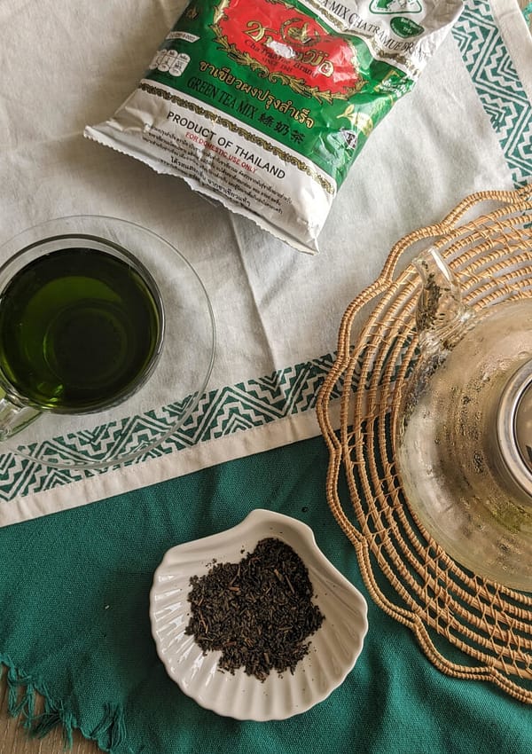 cha tra mue jasmine green tea bag next to a cup of cha tra mue jasmine green tea