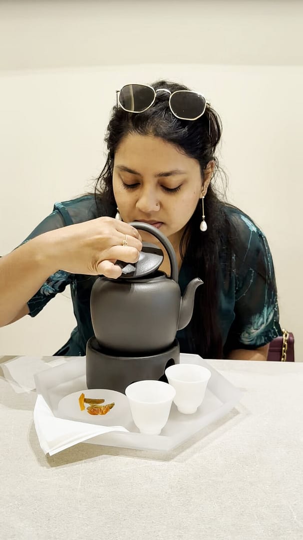 author sniffing tea inside kettle at tea rock kl