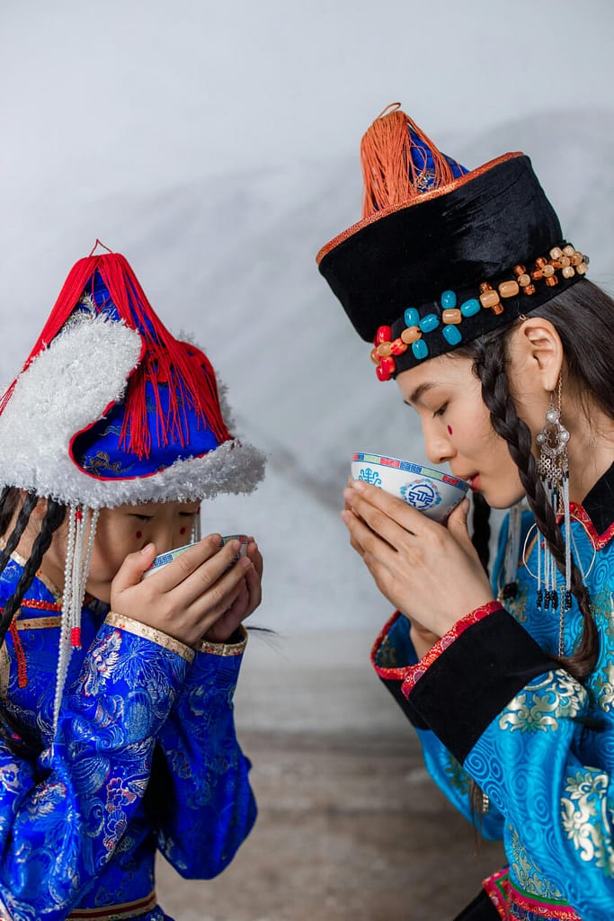 Mother and daughter mindfully drinking tea following Taoism