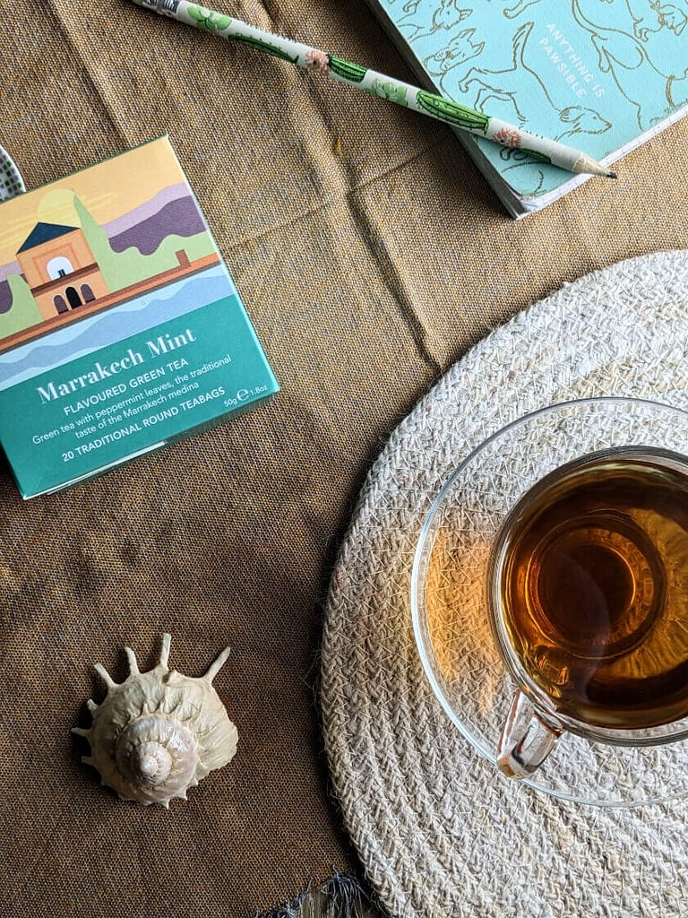 Marrakech Mint Green tea box next to cup of brewed tea
