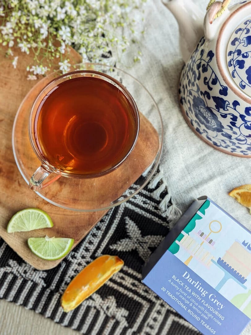 A cup of Whittard Darling Grey next to a box of Whittard Darling Grey teabags